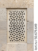 Intricately carved stonework featuring a geometric perforated window design. Стоковое фото, фотограф EugeneSergeev / Фотобанк Лори