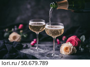 Champagne and red pink roses on a black concrete background. Copy space for text. Valentines drinks for for a pair of lovers. Bartender pours prosecco sparkling wine into glasses. Romance. Wedding Day. Стоковое AI-изображение, AI-художник Марина Демидюк / Фотобанк Лори