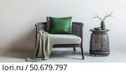 Interior of living room. Gray armchair, green pillow, coffee table and beige wall. Velour Chair against light wall, wooden floor, parquet. Home improvement. Beautiful luxurious modern room settings. Стоковое AI-изображение, AI-художник Марина Демидюк / Фотобанк Лори