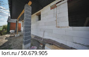 Builders constructing walls of aerated concrete blocks in slavic village. Стоковое видео, видеограф Mikhail Davidovich / Фотобанк Лори
