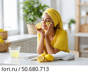 A woman lubricates her face with lemon juice. Стоковое AI-изображение, AI-художник Olga Golub / Фотобанк Лори