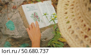 Woman examining a botanical ceramic tile trail marker in a natural park in Capri. Стоковое видео, видеограф Igor Tichonow / Фотобанк Лори