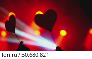 Spectators raising heart shaped signs at concert with red and blue stage lights. Стоковое видео, видеограф Данил Руденко / Фотобанк Лори