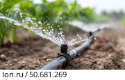 Efficient irrigation system nourishes crops on a farm during daytime. Стоковое AI-изображение, AI-художник Katsiaryna Repich / Фотобанк Лори