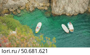 Anchored boats and swimmers in scenic emerald water cove in summer Capri Island. Стоковое видео, видеограф Igor Tichonow / Фотобанк Лори