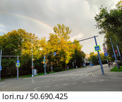 Перекресток на фоне радуги и зеленых деревьев в городе. Москва, Башиловская улица (2024 год). Редакционное фото, фотограф Ирина Терентьева / Фотобанк Лори