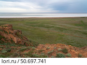 Fancy stones on the slopes of Bolshoe Bogdo Mountain and the salt lake Baskunchak in the distance on a summer day, Bogdinsko-Baskunchak Nature Reserve, Akhtubinsky district, Astrakhan region, Russia. Стоковое фото, фотограф Ula Ulachka / Фотобанк Лори