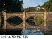 Seimon-seki Bridge and the two-storey keep Fushimi-yagura in the background on a sunny autumn day, Tokyo Imperial Palace, Chiyoda district, Tokyo, Japan. Стоковое фото, фотограф Ula Ulachka / Фотобанк Лори
