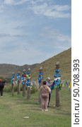 ELANTSY VILLAGE, IRKUTSK REGION, RUSSIA - July 05, 2025: Vertical video of Buddhist Serge pillars with colored ribbons at the sacred Erd mountain. People tie the traditional blue hodak during Erdyn Games festival. Редакционное видео, видеограф Виктория Катьянова / Фотобанк Лори