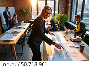 Engineer marking corrections on large project blueprint. Стоковое AI-изображение, AI-художник Mariya Suranova / Фотобанк Лори