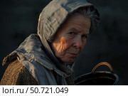 Senior woman carrying basket wearing headscarf and scarf facing poverty and hardship. Стоковое AI-изображение, AI-художник Иван Рябоконь / Фотобанк Лори