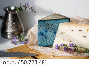 A piece of blue, fresh, aged, natural farm cheese with lavender on a wooden board. Unusual taste and quality of farm-fresh agricultural products. Стоковое фото, фотограф Photojuli / Фотобанк Лори