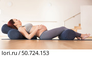 pregnant woman is engaged in yoga. Reclined Bound Angle Pose or Supta Baddha Konasana. Стоковое фото, фотограф Татьяна Яцевич / Фотобанк Лори