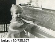 Ребёнок у пианино Graham & Lamy. Играет двумя руками. 28.09.1953. Стоковое фото, фотограф Retro / Фотобанк Лори