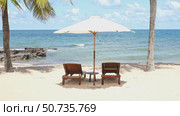 Two sun loungers bed under an umbrella on sandy beach. Summer all year round concept. Cuba Varadero Beach View on Atlantic Ocean. Sunny Tropical Seascape with Palm Trees. Summer Nature Background. Стоковое видео, видеограф Ирина Михайличенко / Фотобанк Лори