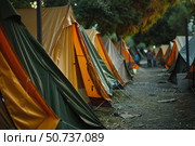Colorful camping tents standing in a row at dusk. Стоковое AI-изображение, AI-художник Иван Рябоконь / Фотобанк Лори