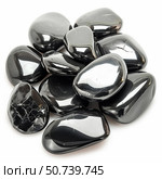 Black tumbled hematite gemstones reflecting light on white background. Стоковое AI-изображение, AI-художник Иван Рябоконь / Фотобанк Лори