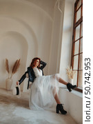 Embracing Unconventional Elegance a Bride Rests by the Window in the Studio. Стоковое фото, фотограф Aleksandr Golubev / Фотобанк Лори
