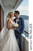 Couple Kissing on a Boat With a Serene Water Backdrop, Bride With Bouquet. wedding Planning and Honeymoon Ideas. Стоковое AI-видео, аниматор Sergey Grishin / Фотобанк Лори