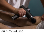 Innovative Therapy Session Using Percussion Massage Technique to Relieve Muscle Tension. Стоковое фото, фотограф Aleksandr Golubev / Фотобанк Лори