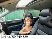 Boy is sitting in a car with his head on the back of the headrest. Стоковое фото, фотограф Дмитрий Брусков / Фотобанк Лори