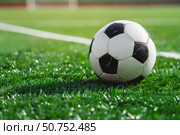 Soccer ball resting on lush green artificial turf field. Стоковое AI-изображение, AI-художник Иван Рябоконь / Фотобанк Лори