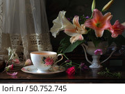 Cup of tea resting on table near daylilies and lace curtain. Стоковое AI-изображение, AI-художник Иван Рябоконь / Фотобанк Лори
