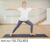 Pregnant woman is engaged in yoga. Warrior Pose or Virabhadrasana. Стоковое фото, фотограф Татьяна Яцевич / Фотобанк Лори