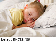 Peaceful adorable baby sleeping on a bed at home. Slumbering little child. Two years old girl sleeps peaceful at domestic room interior background. Serene dream. Cute face close up. Deep kid slumber. Стоковое фото, фотограф Марина Демидюк / Фотобанк Лори