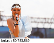 ELANTSY, IRKUTSK REGION, RUSSIA - July 5, 2025: Erdynskie Games – festival of nomadic peoples of Eurasia. Beautiful Buryat girl on an open stage takes part in beauty contest and sings fiery song. Редакционное фото, фотограф Виктория Катьянова / Фотобанк Лори
