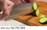 A knife is cutting a cucumber on a wooden cutting board. Стоковое видео, видеограф Ярославский Максим / Фотобанк Лори
