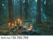 Burning candles and extinguished fire creating a magical atmosphere in mystical forest. Стоковое AI-изображение, AI-художник Иван Рябоконь / Фотобанк Лори