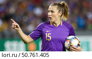 Female soccer player in purple jersey giving directions during competitive match, team leader pointing on football field during game. Стоковое AI-изображение, AI-художник Павел Муравьев / Фотобанк Лори