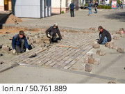 Рабочие кладут брусчатку в центре Калининграда (2011 год). Редакционное фото, фотограф Сергей Куров / Фотобанк Лори