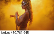 A woman in a gold outfit with a mask on her face. Стоковое AI-видео, аниматор Виктория Кольцова / Фотобанк Лори