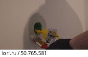 Careful painting of the walls with a brush near the holes for sockets. Apartment renovation, preparation for electricity connection and installation of plastic outlets. Стоковое видео, видеограф Darya Komarova / Фотобанк Лори