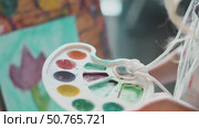 Close-up of child choosing colors from palette. Moment of inspiration reflects joy of self-expression, imagination, and creativity in a supportive space. Стоковое видео, видеограф Енваев Андрей / Фотобанк Лори