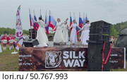 ANGARSK, IRKUTSK REGION, RUSSIA - July 13, 2025: XV International Silk Way Rally, racing competition. Video of girls in white dresses dancing on open stage before the start of rally in summer rainy day. Редакционное видео, видеограф Виктория Катьянова / Фотобанк Лори