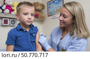 Nurse administering vaccine to young boy in clinic. Стоковое AI-изображение, AI-художник Юрий Поздников / Фотобанк Лори