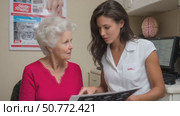 Female doctor showing medical scan results to senior patient. Стоковое AI-видео, аниматор Юрий Поздников / Фотобанк Лори