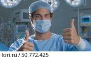 Confident surgeon gesturing thumbs up in operating room. Стоковое AI-видео, аниматор Юрий Поздников / Фотобанк Лори