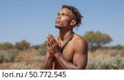 Indigenous man praying in the desert. Стоковое AI-видео, аниматор Юрий Поздников / Фотобанк Лори