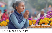 Devout senior woman praying at day of the dead offering. Стоковое AI-видео, аниматор Юрий Поздников / Фотобанк Лори