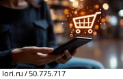 Woman using a smartphone for online shopping with a glowing digital cart icon, symbolizing e-commerce, mobile retail, and technology-driven consumer behavior. Стоковое AI-изображение, AI-художник Катерина Бондарец / Фотобанк Лори