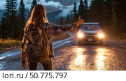 Female backpacker hitchhiking on wet mountain road at dusk, with headlights approaching, symbolizing adventure, travel, freedom, and spontaneous exploration in nature. Стоковое AI-изображение, AI-художник Катерина Бондарец / Фотобанк Лори