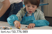 little boy is engaged in process of making handmade garments during an art class. Стоковое видео, видеограф Strunov David / Фотобанк Лори