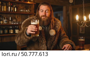 Man in fur coat drinking beer at wooden bar with warm lighting. Стоковое AI-видео, аниматор Андрей Бажанов / Фотобанк Лори