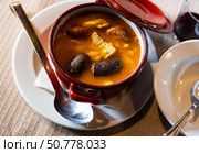There is traditional Spanish dish on  table - Fabada Asturian in pot. Стоковое фото, фотограф Яков Филимонов / Фотобанк Лори