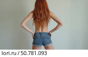 Confident Woman in Shorts and Stylish Outfit, With Vibrant Red Hair, Poses in a Minimalistic Setting. Fashion Photography. Стоковое AI-видео, аниматор Sergey Grishin / Фотобанк Лори