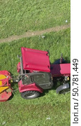 Vertical video about the work of a special mini tractor for mowing grass on a city lawn on a sunny summer day. View from above. Стоковое видео, видеограф Виктория Катьянова / Фотобанк Лори